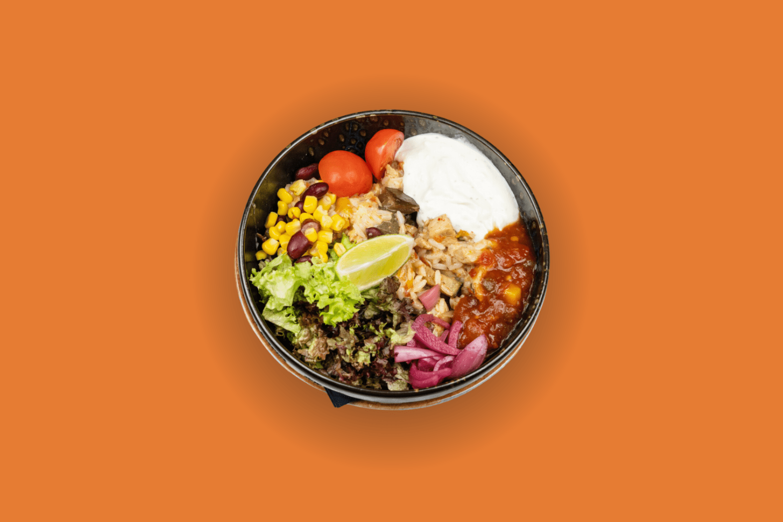 Bowl mit Hähnchen, Grillgemüse, Reis, Käse, Limette und eingelegten Zwiebeln